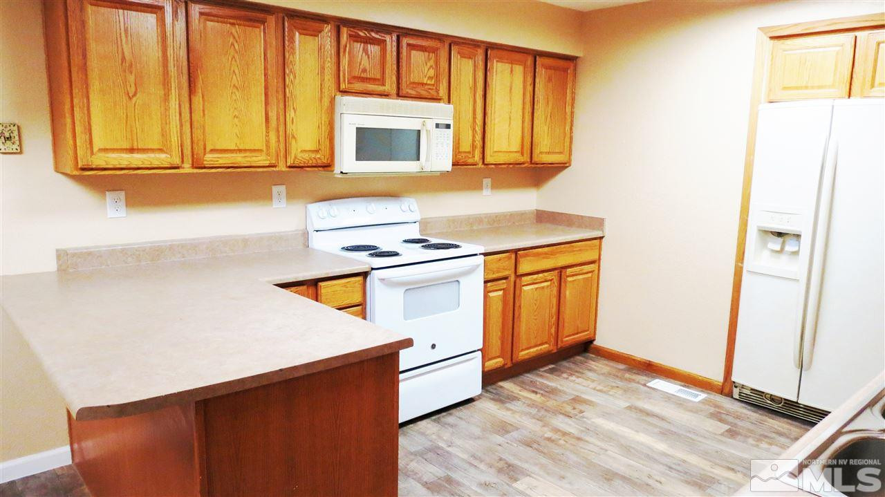 6525 Lotus Street Reno, NV 89506 - Photo 7 of 25 a kitchen with stainless steel appliances granite countertop a stove a microwave and a refrigerator