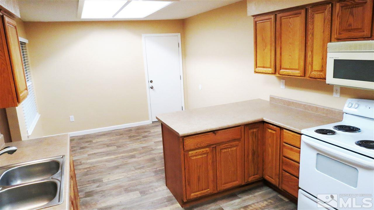 6525 Lotus Street Reno, NV 89506 - Photo 9 of 25 a kitchen with a sink cabinets and a stove top oven