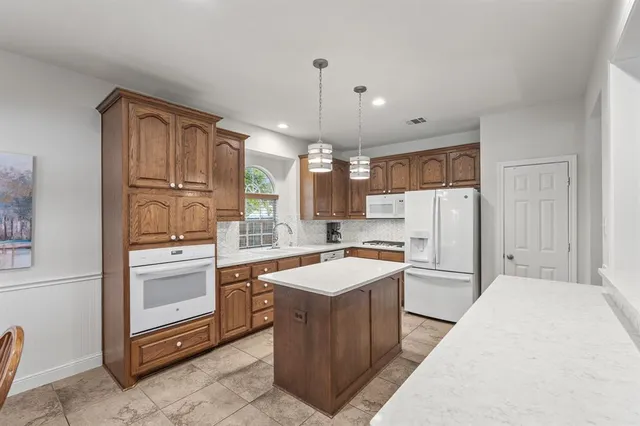 a kitchen with refrigerator cabinets and wooden floor