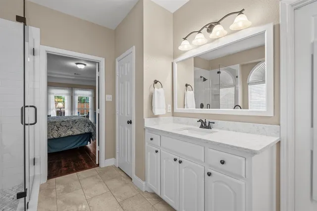 a en suite bathroom with a granite countertop sink and a mirror