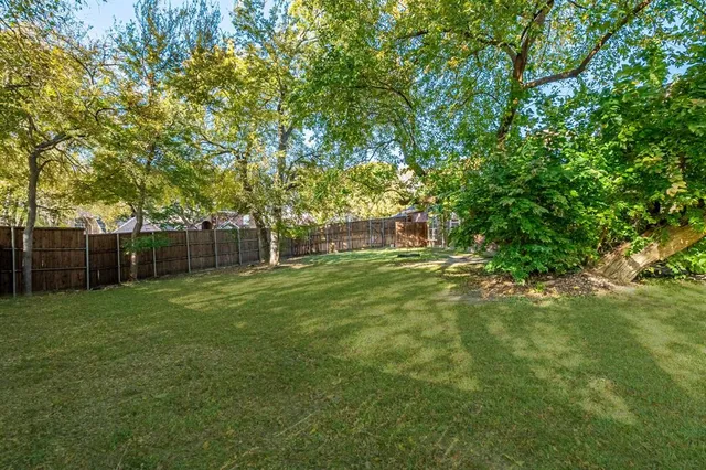 a backyard of a house with lots of plants and tree