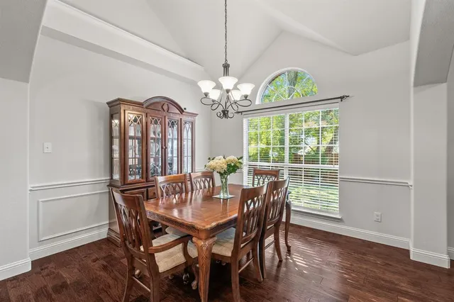 a dining room with furniture a chandelier and wooden floor
