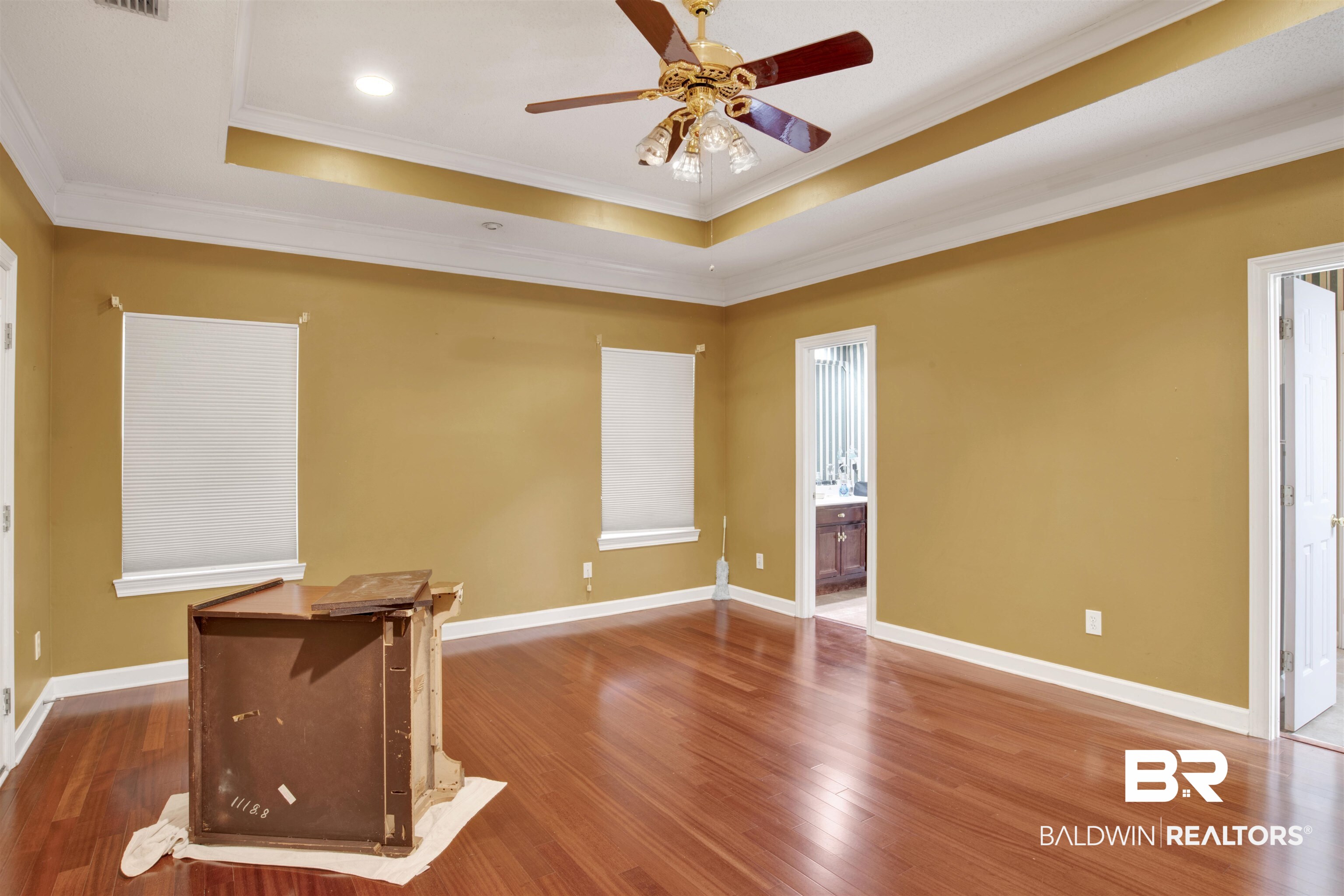 445 Wedgefield Drive South Mobile, AL 36608 - Photo 19 of 36 Unfurnished room with hardwood / wood-style flooring, ceiling fan, ornamental molding, and a tray ceiling