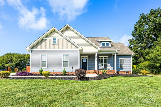 a view of a house with backyard and a tree