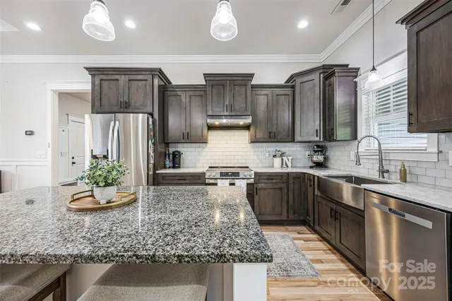 a kitchen with stainless steel appliances granite countertop a sink stove and refrigerator