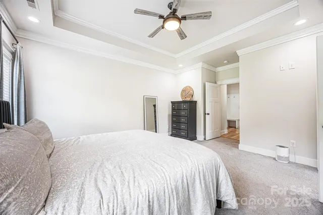 a spacious bedroom with a bed and a chandelier