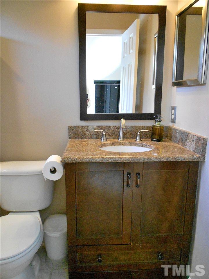 3823 Carnegie Lane Raleigh, NC 27612 - Photo 14 of 25 a bathroom with a granite countertop sink and a mirror