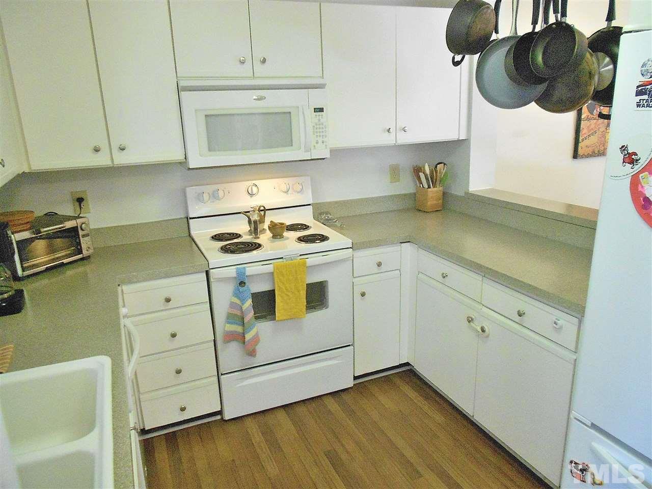 3823 Carnegie Lane Raleigh, NC 27612 - Photo 7 of 25 a kitchen with white cabinets and white appliances