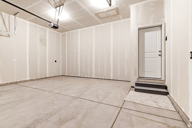 7243 West Terraine Road West Jordan, UT 84081 - Photo 30 of 31 Spacious garage with unfinished walls, concrete flooring, and an overhead garage door opener