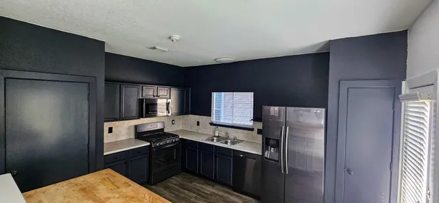 a kitchen with stainless steel appliances granite countertop a refrigerator and a stove top oven