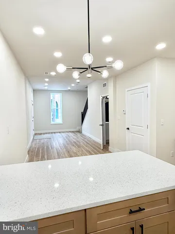 a living room with kitchen island furniture and a chandelier