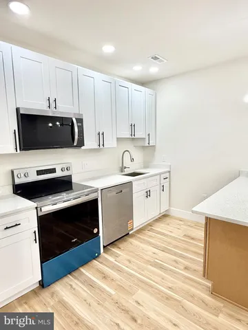 a kitchen with a sink and white cabinets