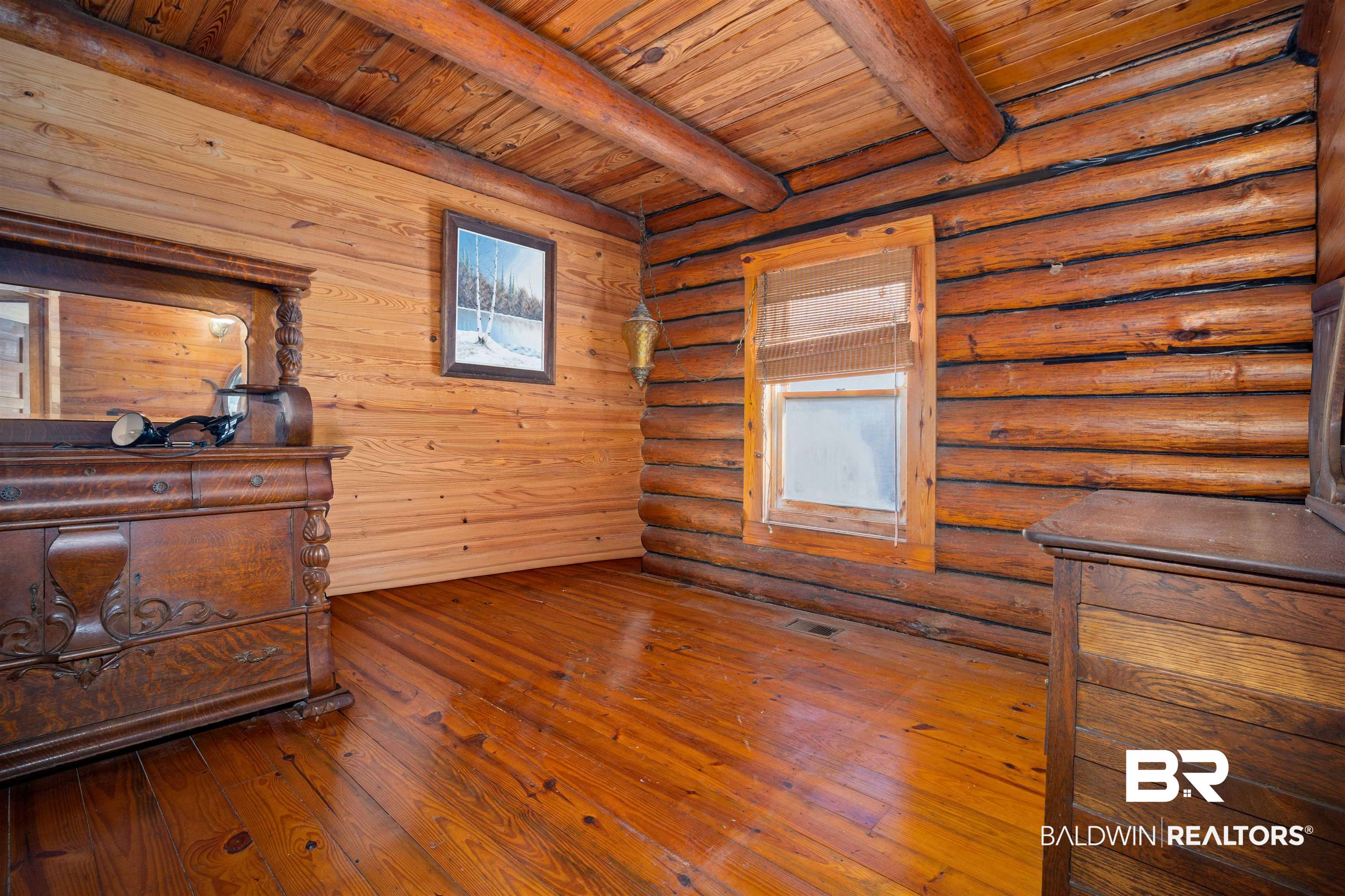 11236 Wren Avenue Fairhope, AL 36532 - Photo 17 of 35 Unfurnished bedroom with a wooden ceiling with exposed beams, hardwood / wood-style flooring, and log walls