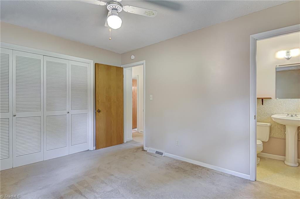 2606 Maxine Drive High Point, NC 27265 - Photo 14 of 34 Primary bedroom features ensuite half bathroom, ceiling fan, and large closets.