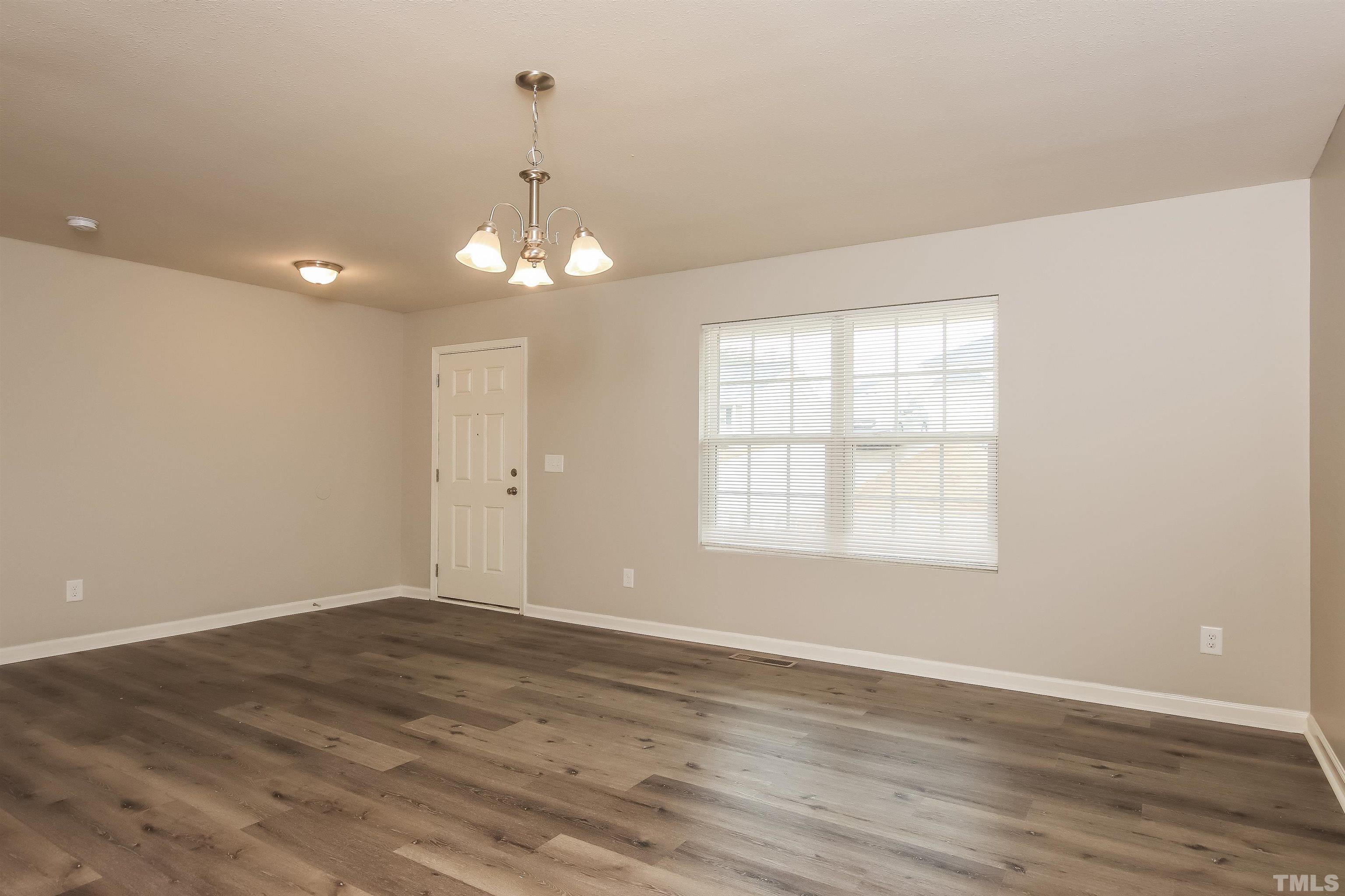 333 Sequoia Drive Clayton, NC 27527 - Photo 6 of 17 an empty room with wooden floor and windows