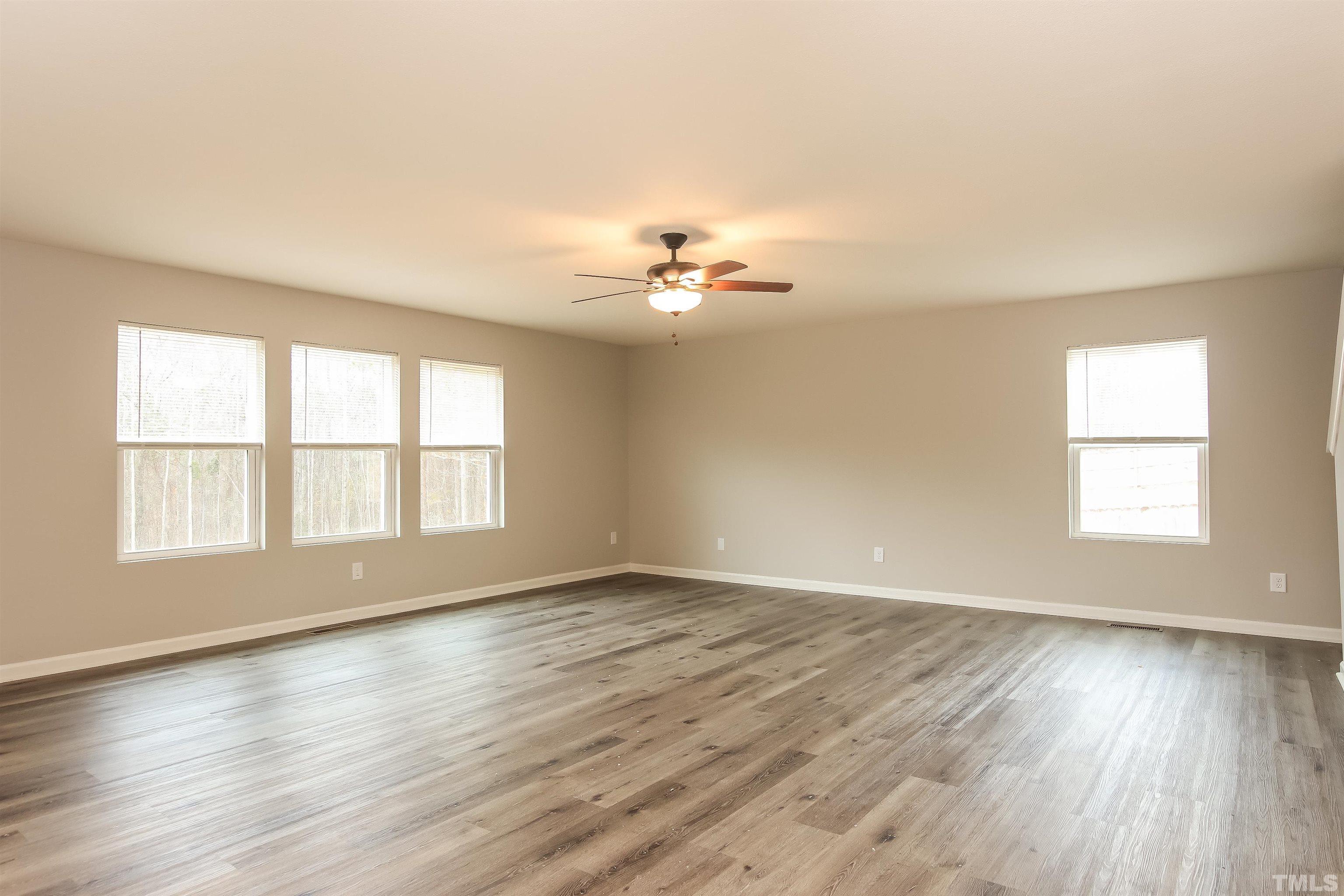 333 Sequoia Drive Clayton, NC 27527 - Photo 9 of 17 an empty room with wooden floor and windows