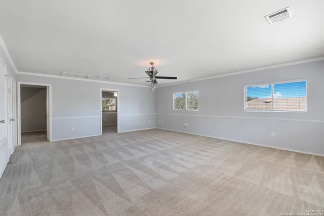 an empty room with windows and fan