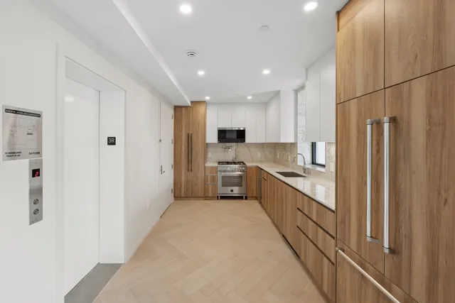 a large kitchen with a refrigerator and white cabinets