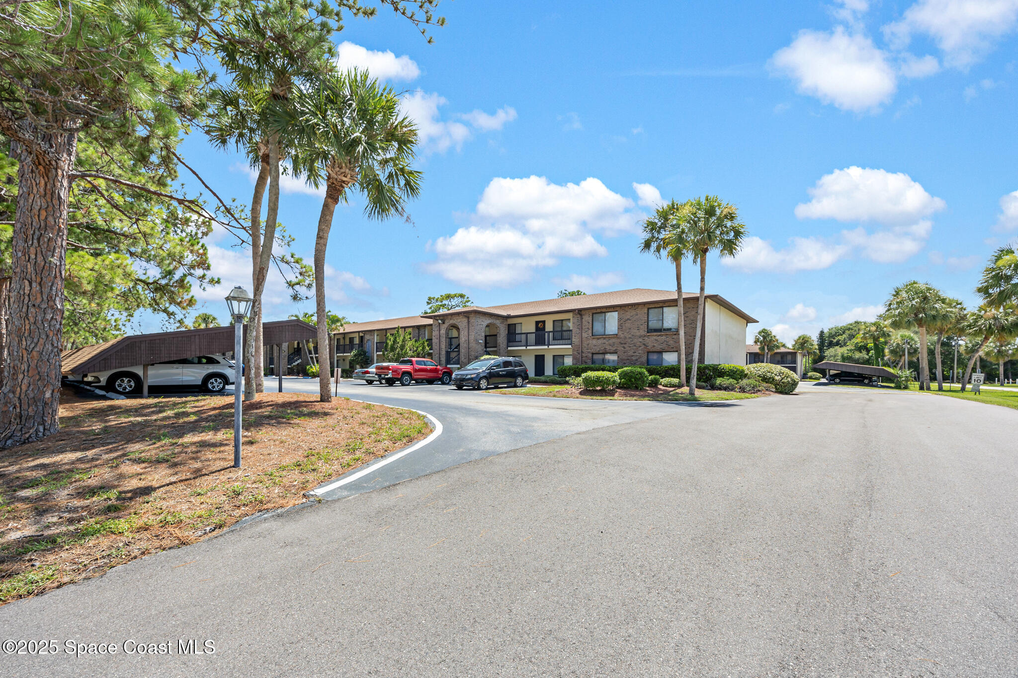 1515 Huntington Lane, Unit 227 Rockledge, FL 32955 - Photo 14 of 14 a front view of a house with a garden and trees