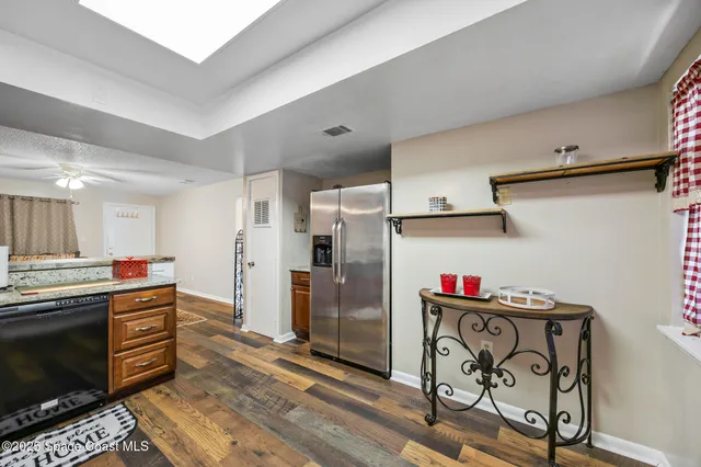 a kitchen with granite countertop a refrigerator and a stove top oven