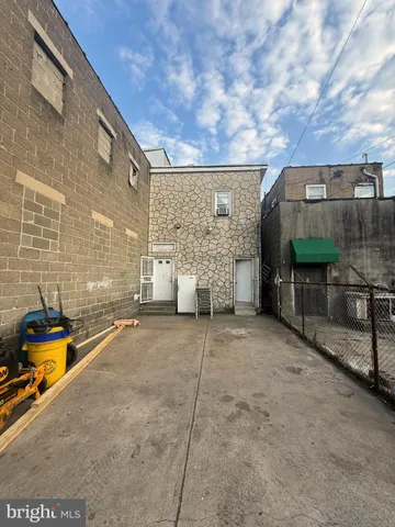 a backyard of a house with barbeque oven and outdoor seating