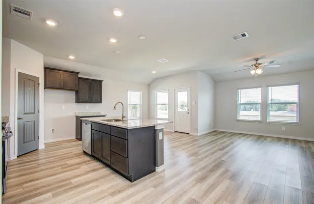 a kitchen with stainless steel appliances granite countertop a sink stove and wooden floor