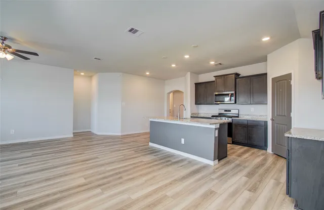 a kitchen with stainless steel appliances kitchen island wooden cabinets and granite counter tops