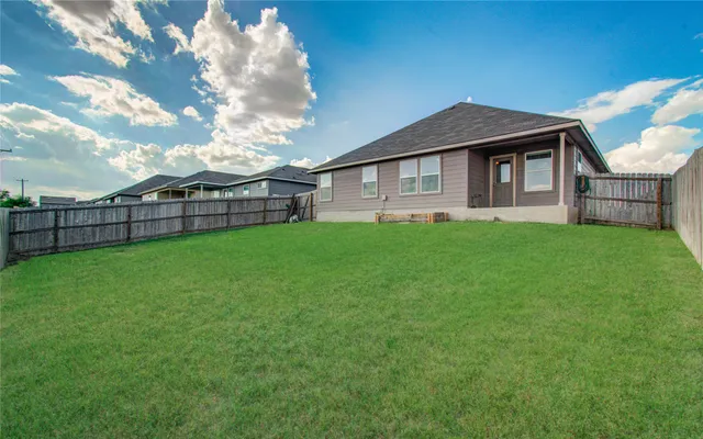 a front view of a house with a yard and trees