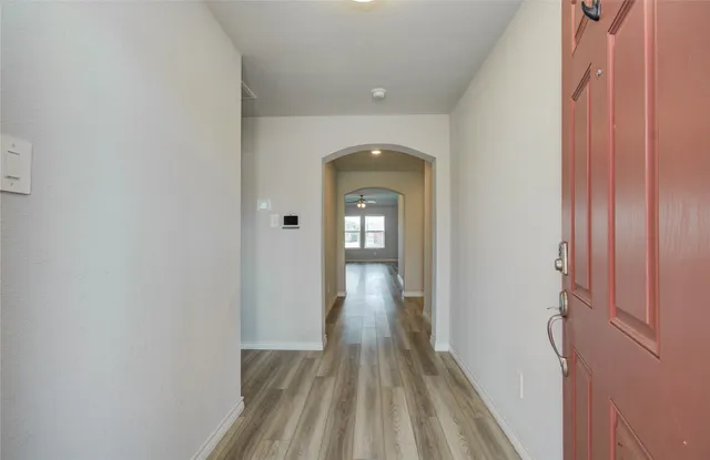 a view of a hallway with wooden floor
