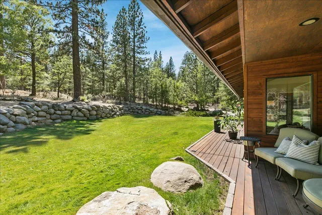 a view of a chair and table in backyard with wooden fence