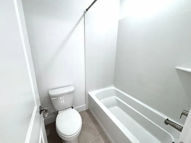 a white toilet sitting next to a bath tub