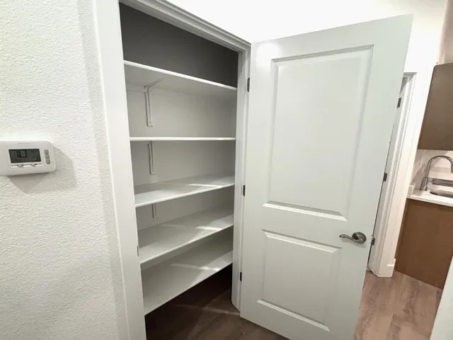 a view of walk in closet with empty racks