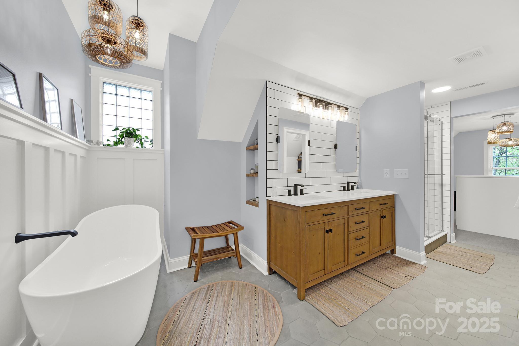 110 Sonnys Way Fort Mill, SC 29708 - Photo 31 of 48 a spacious bathroom with a double vanity sink a mirror a bathtub and a window