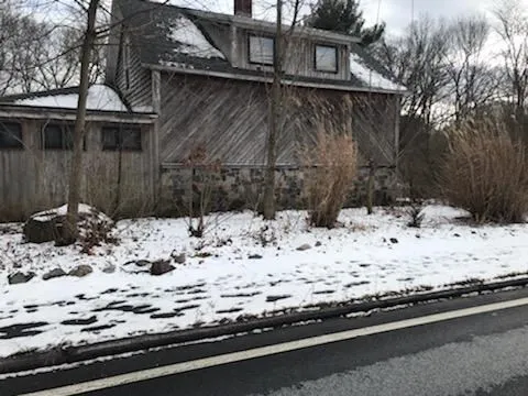 a view of white house with a yard covered in snow