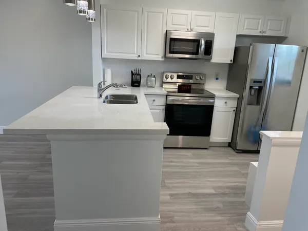 a kitchen with stainless steel appliances a refrigerator stove microwave and sink