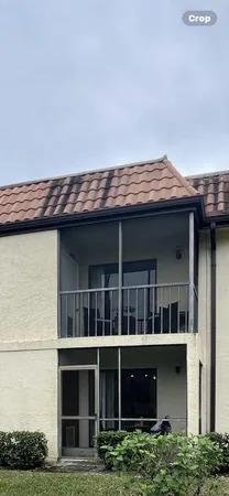 a front view of a house with a yard and potted plants