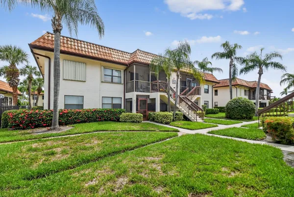 a view of a house with a yard and sitting area