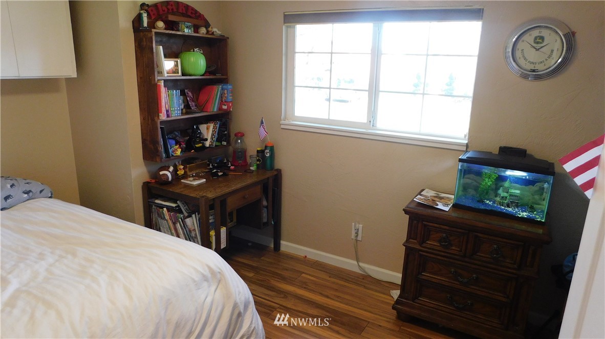 18419 Nutmeg Street Southwest Rochester, WA 98579 - Photo 18 of 24 a bedroom with a bed and a bookshelf with the wooden floor