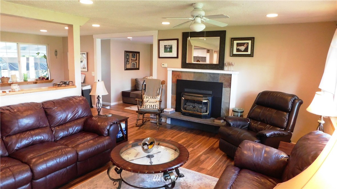 18419 Nutmeg Street Southwest Rochester, WA 98579 - Photo 4 of 24 a living room with furniture a fireplace and a chandelier