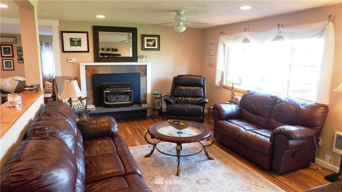 18419 Nutmeg Street Southwest Rochester, WA 98579 - Photo 5 of 24 a living room with furniture a large window and a fireplace