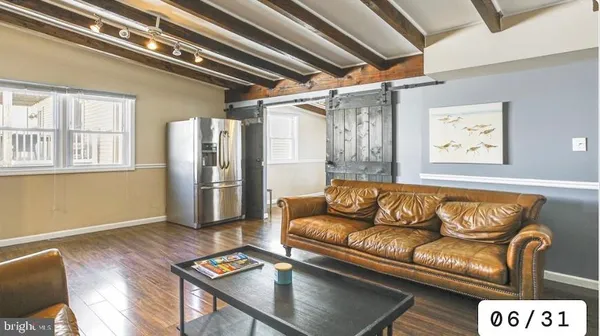 a kitchen with stainless steel appliances granite countertop a refrigerator a sink dishwasher a stove and white countertops with wooden floor