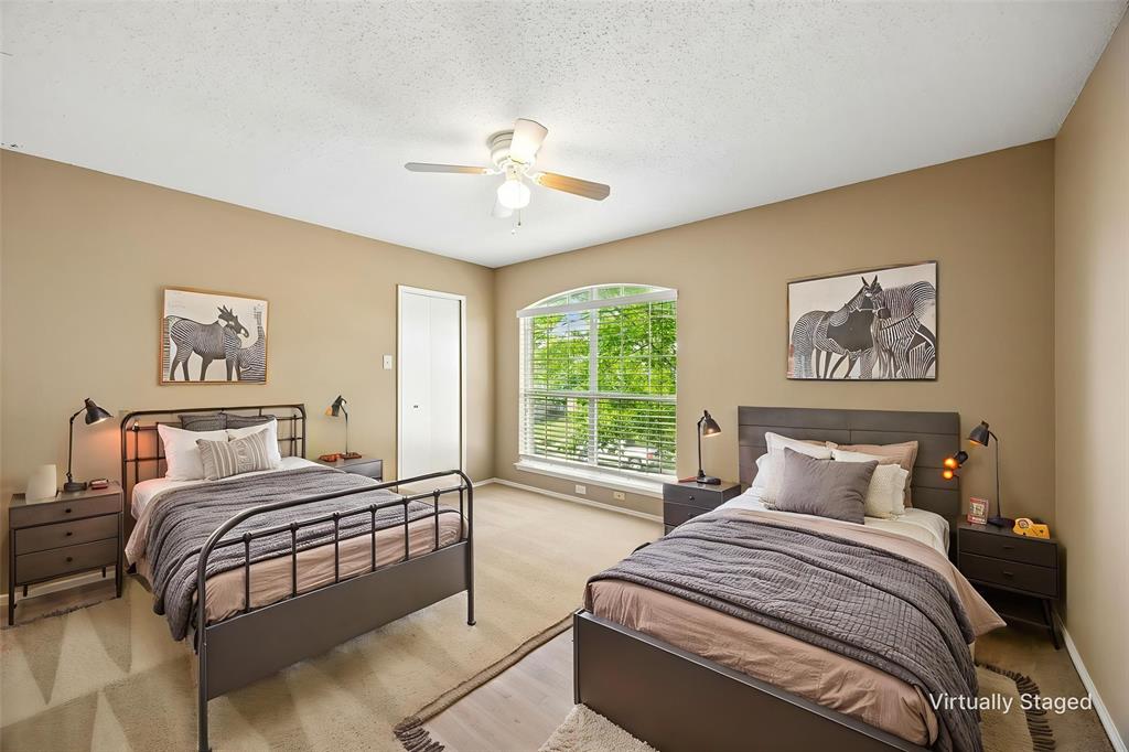 584 Pendleton Drive Rockwall, TX 75032 - Photo 18 of 28 a bedroom with a large bed and a chandelier