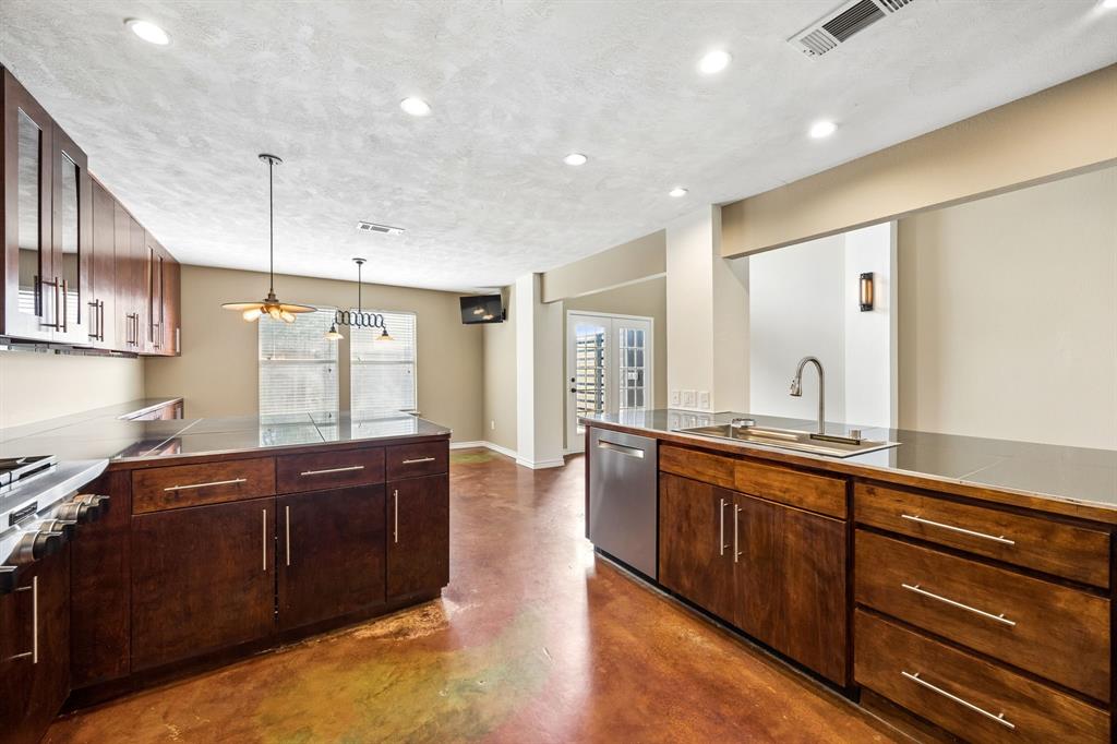 584 Pendleton Drive Rockwall, TX 75032 - Photo 3 of 28 a large kitchen with stainless steel appliances granite countertop a sink and wooden cabinets