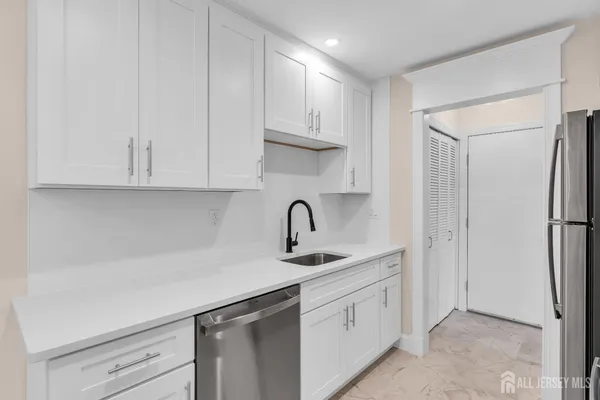 a kitchen with white cabinets stainless steel appliances and sink