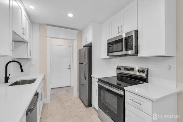 a kitchen with stainless steel appliances a stove microwave and sink