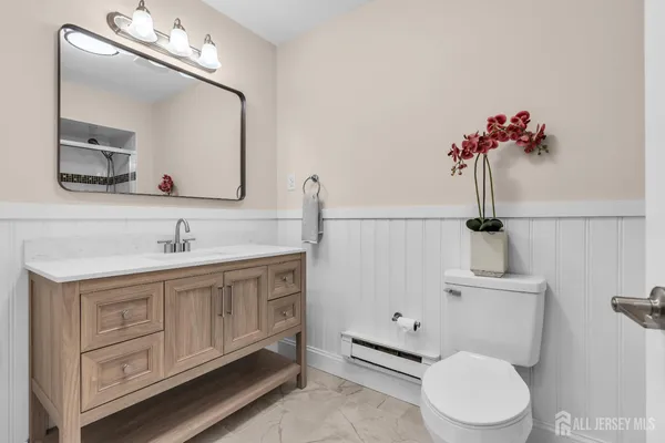 a bathroom with a toilet a sink and mirror
