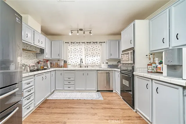 a kitchen with granite countertop a sink stainless steel appliances and cabinets
