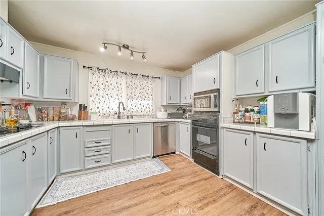 a kitchen with granite countertop white cabinets and white appliances
