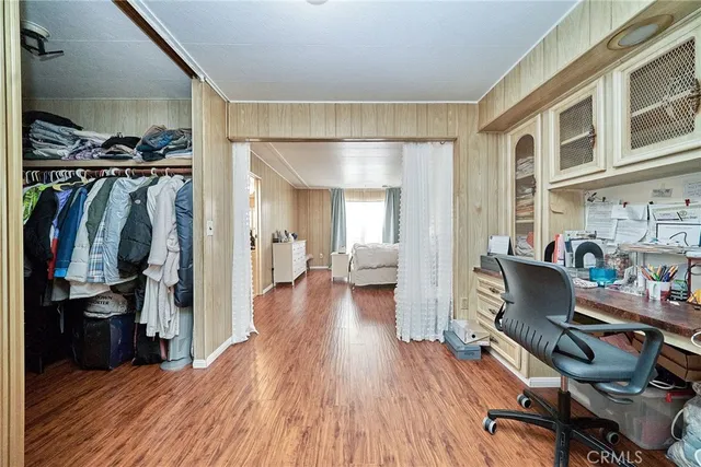 a view of a walk in closet with clothes and shoes
