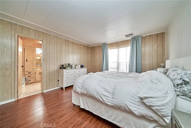 a spacious bedroom with a bed and a cabinet